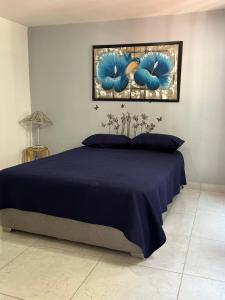 Un dormitorio con una cama con un edredón azul. en Aparta Hotel Monaco, en Barranquilla