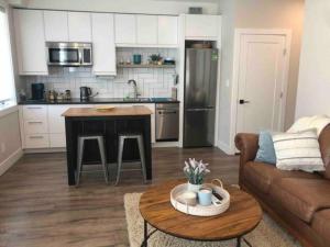 a kitchen and living room with a couch and a table at Executive 1 Bedroom Lakeview Retreat in Shawnigan Lake
