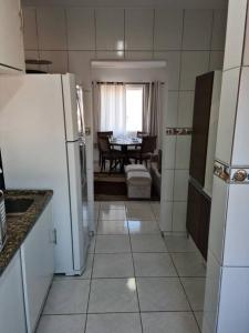 a kitchen with white appliances and a dining room with a table at espaço especial em SJP in São José dos Pinhais +6 photos