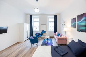 a living room with a bed and blue chairs at Radiant Premium Apartments - Fünfhaus in Vienna