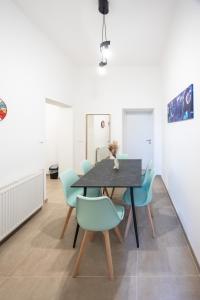 a dining room with a black table and blue chairs at Radiant Premium Apartments - Fünfhaus in Vienna
