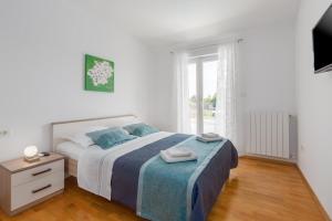 a white bedroom with a bed and a window at Villa Tonka in Nova Vas +37 photos