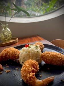 a plate of food with fried food and rice at Hotel Porto Di Mare in Ubatuba
