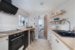 a kitchen with a sink and a stove top oven at Lighthouse Cottage Unique Apartments in Scarborough +42 photos