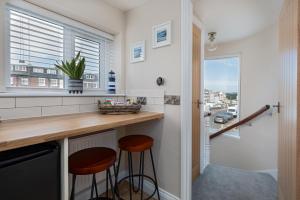 a kitchen with two stools at a counter with a window at Lighthouse Cottage Unique Apartments in Scarborough