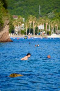 a person swimming in a large body of water at Herceg Novi Seaside Retreat with Serene Garden in Zelenika