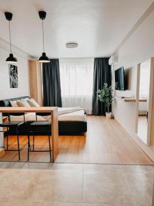 a room with a bed and a table and chairs at AGOLL Victoria - self checkin in Reşiţa