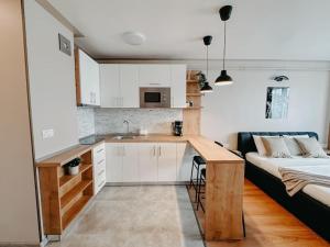 a kitchen with a table and a bed in a room at AGOLL Victoria - self checkin in Reşiţa