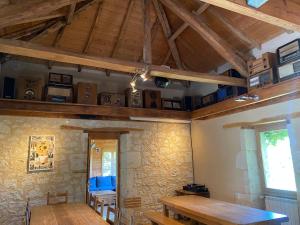 Saint-Amans-de-PellagalにあるVilla Stephano top pour un week-end festifの木製のテーブルと天井の高いダイニングルーム