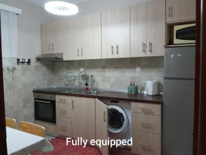 a kitchen with a sink and a washing machine at Medusa Beach Apartment, Asprovalta in Asprovalta
