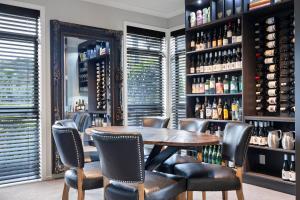 a dining room with a table and chairs and wine bottles at Kaitahi Lodge in Palmerston North