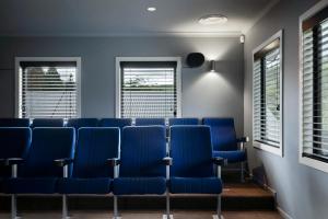 a conference room with blue chairs and windows at Kaitahi Lodge in Palmerston North