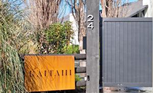 a gate with a sign that says mendelin at Kaitahi Lodge in Palmerston North
