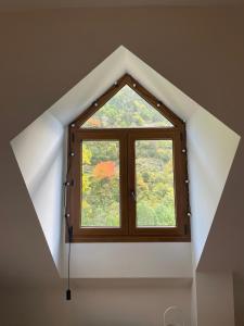 a small window in a room with a roof at CALMFRANC ático abuhardillado con vistas al río y la montaña Avistamiento de ciervos en Canfranc Pueblo in Canfranc