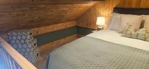 a bedroom with a large bed with a wooden wall at Mount Bolton Loft House in Portlaw