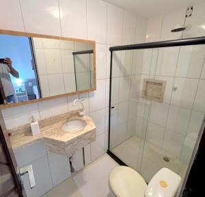 a bathroom with a shower and a toilet and a sink at Casa em Condomínio Privativo in Lauro de Freitas +20 photos