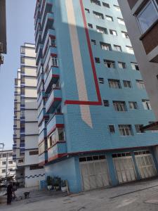 Un edificio alto de apartamentos con una pintura en él. en Miami Beach, en Praia Grande