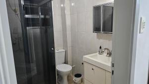 Un baño con inodoro, ducha y lavabo. en Miami Beach, en Praia Grande