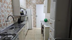 una cocina con fregadero y refrigerador en Miami Beach, en Praia Grande