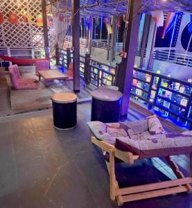 een kamer met een bank en wat tafels en stoelen bij Moonland Bar and Hostel in Haad Rin