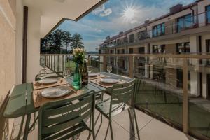 a balcony with a glass table and chairs on a balcony at Kisajno 30 in Giżycko