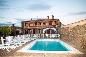 a swimming pool in front of a building with chairs at Villas de Miranda in Miranda de Azán