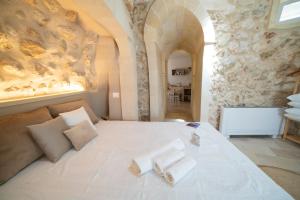Castrignano deʼ GreciにあるLisària Villa Delle Meraviglie With Poolのベッドとタオル2枚のある寝室