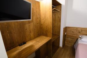a bedroom with a wooden wall with a tv on it at Piazza Cavour in LʼAquila