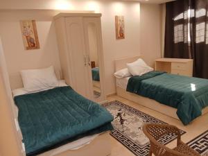 une chambre avec deux lits et un miroir dans l'établissement skn hotal, à Mansoura