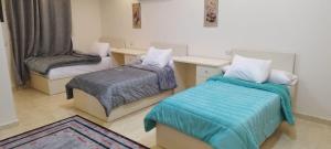 une petite chambre avec deux lits et une chaise dans l'établissement skn hotal, à Mansoura 30 autres photos