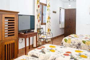 a bedroom with two beds and a flat screen tv at Hotel Valsequillo in Lepe