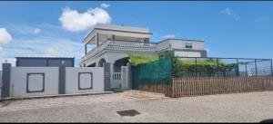 a white house with a fence and a gate at سمارت شالية:Smart Chalet in Salalah +6 photos