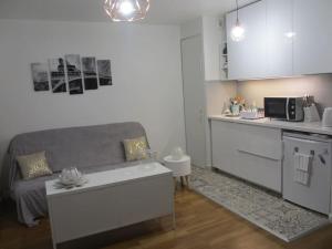 a living room with a couch and a kitchen at RER C Les Grésillons NEAR PARIS in Asnières-sur-Seine