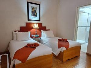 a hotel room with two beds with bows at Hotel del Capitán de Puebla - Vitrales in Puebla