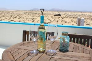 Una mesa con una botella de vino y dos copas. en Villa Eesha by Privilege Bay, en La Oliva
