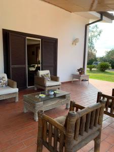 a patio with a couch and a table and chairs at Villa Garden in Sabaudia