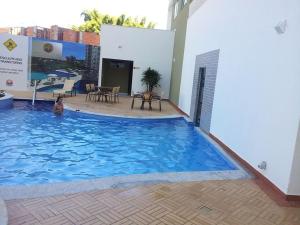 a dog is sitting in a large swimming pool at Riviera Park in Caldas Novas