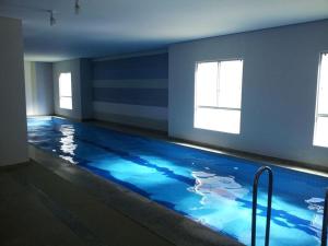 a large swimming pool with blue water in a room at Riviera Park in Caldas Novas