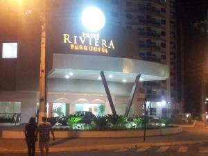 two people walking in front of a riviera palace hotel at night at Riviera Park in Caldas Novas