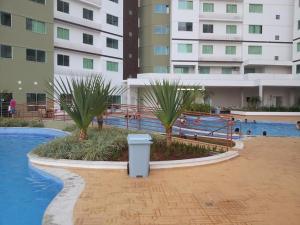 a swimming pool with a trash can in front of a building at Riviera Park in Caldas Novas