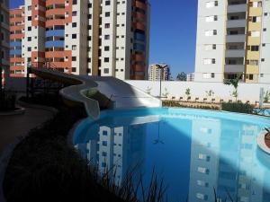 a swimming pool with a slide in front of some buildings at Riviera Park in Caldas Novas