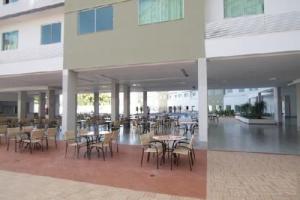 a cafeteria with tables and chairs in a building at Riviera Park in Caldas Novas