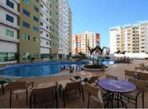 a patio with a table and chairs and a swimming pool at Riviera Park in Caldas Novas