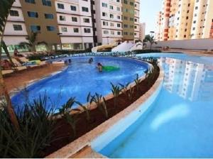 a large swimming pool with blue water in a building at Riviera Park in Caldas Novas