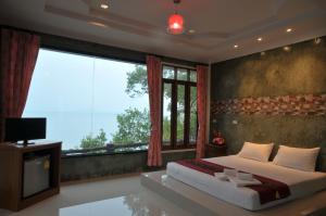 een slaapkamer met een bed en een groot raam bij I Talay Lanta in Koh Lanta
