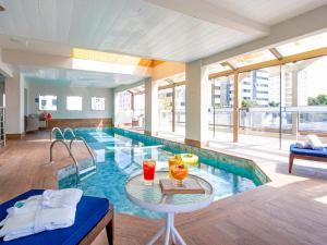 a large swimming pool with a table in a building at Suíte Master em Hotel Florianópolis in Florianópolis