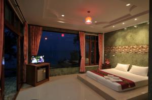 a bedroom with a bed and a large window at I Talay Lanta in Ko Lanta