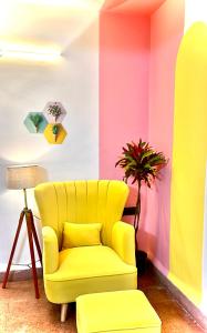 a yellow chair and a plant in a room at The Gharaundha in Orlim