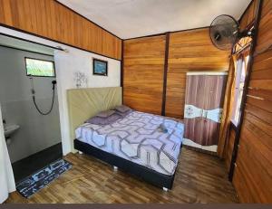 a bedroom with a bed in the corner of a room at Naca Homestay in Manado