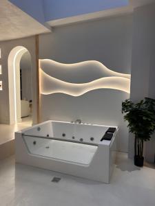 Un baño con bañera blanca en una habitación. en Capsule ciné glisse - cinéma - spa balnéo - garage, en Roubaix 15 fotos más